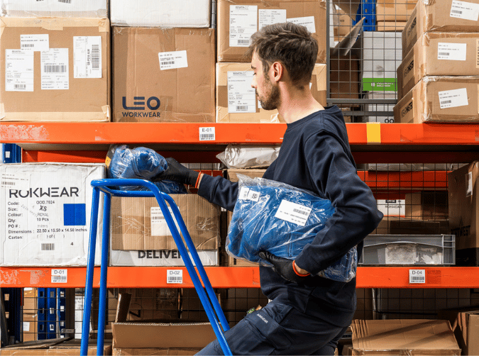 Warehouse worker up a ladder.